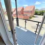 View from balcony onto residential street and houses.