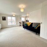 Bright living room with blue sofa and windows