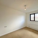 Empty room with carpet and window view.