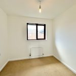 Empty room with beige carpet and window.