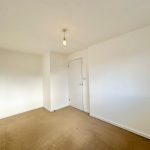 Empty room with white walls, beige carpet.