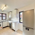 Modern kitchen with appliances and large window.