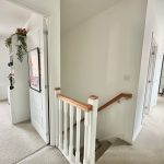 Bright hallway with open doors and staircase.