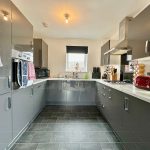 Modern kitchen with grey cabinets and appliances.