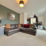 Cosy living room with dark sofas and artwork.