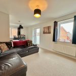 Bright living room with black leather sofa.