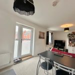 Modern living room with dining table and TV.