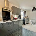 Modern kitchen with grey cabinets and appliances.