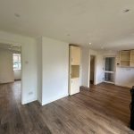 Modern empty kitchen with wooden flooring.