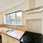 Modern kitchen with cooker hood and wooden worktop