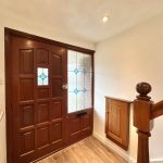 Wooden front door with glass panel detail.