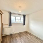 Empty bright room with wooden floor and wardrobe.