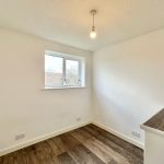 Small white room with wooden floor.