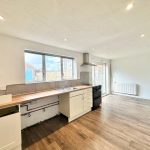 Bright open-plan kitchen with wood flooring