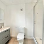 Modern white bathroom with shower and vanity.