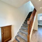 Carpeted stairs and wooden floor hallway.