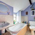 Cosy bathroom with bathtub and purple walls.