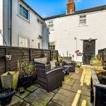 Cosy backyard with garden furniture and potted plants.