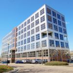 Modern office building with cars in car park