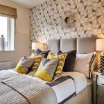 Stylish bedroom with geometric patterned wallpaper and pillows.