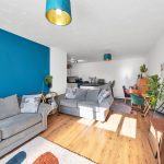 Modern living room with blue accent wall and plants.