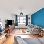 Modern living room with blue accent wall and sofa.