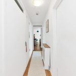 Bright, narrow hallway leading to living room.