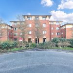 Modern red brick apartment building with trees