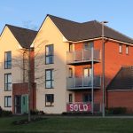 Modern residential building with sold banner.