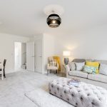 Modern living room with grey sofa and dining area