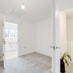 Bright modern hallway with open door to bathroom.