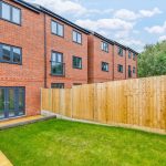 Modern brick building with fenced garden