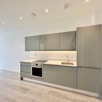 Modern kitchen with grey cabinets and wooden floor