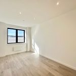 Bright empty room with wooden floor and windows