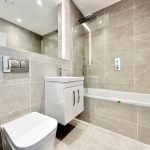 Modern bathroom with sink, toilet, and bath.