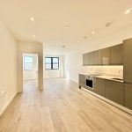 Modern flat with open-plan kitchen and wooden flooring.