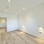 Empty room with wooden floor and white walls.