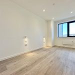 Empty room with wooden floor and large window.