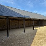 Open barn with gravel and brick walls.