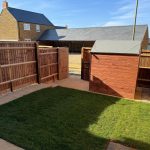 Backyard garden with shed and wooden fence.