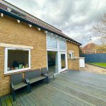 Modern patio with wooden decking and seating area.