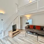 Modern living room with mezzanine, sofa, TV.