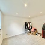 Bright room with clothes rail and suitcases.