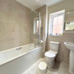 Modern bathroom with bath, sink, and toilet.