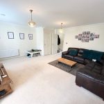 Spacious living room with leather sofa and artworks.