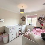 Children's bedroom with cot and decorations.