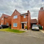 Red brick house with two cars parked outside.