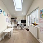 Bright playroom with desk, chairs, and educational decor.